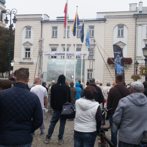 Mieszkańcy obserwujący polmaraton na telebimie